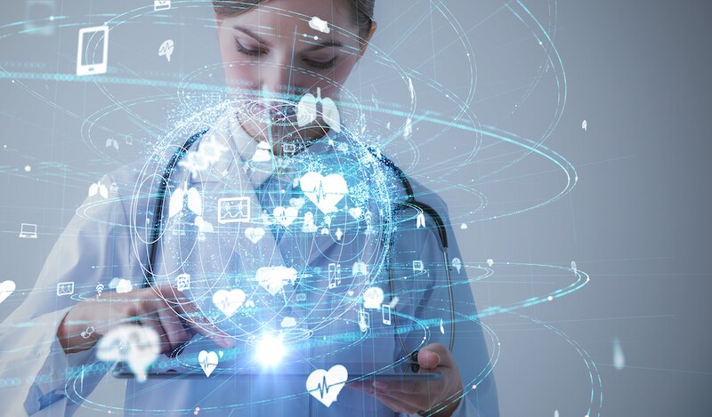 A researcher looks at a tablet, surrounded by graphics that represent participant data in large-scale genomics screening program