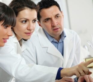 Doctors working together in lab looking at computer display.