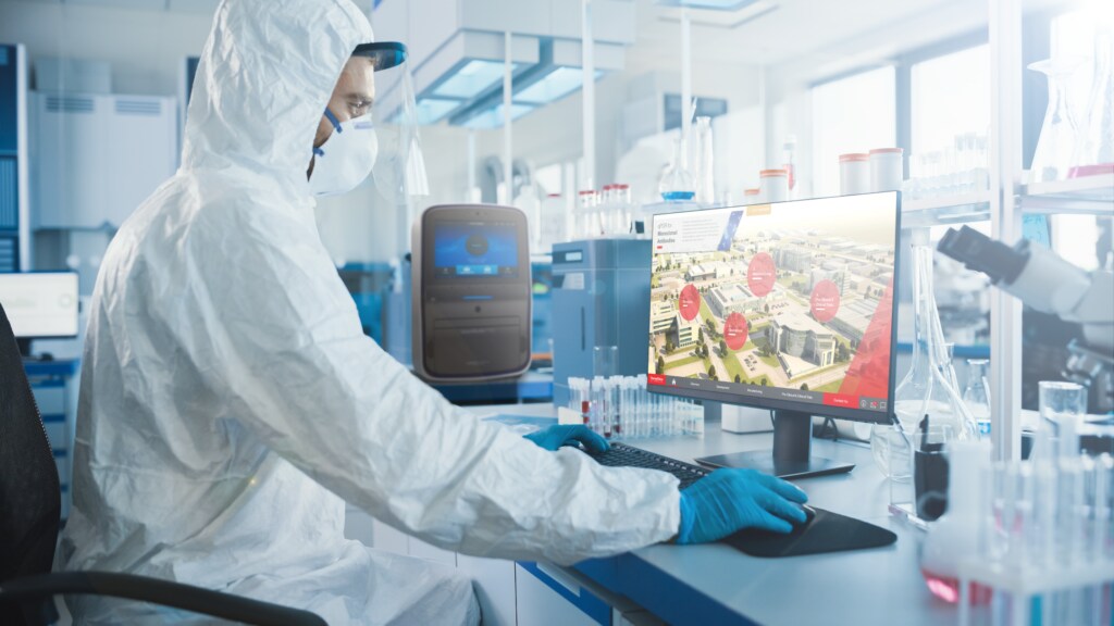 QualTrak Ecosystem is Full-Featured and Supports Regulatory Compliance Scientist in clean room suit and mask sitting at work table with computer logged into portal