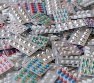 Big heap of various pills and tablets packs and blisters.