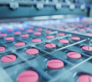 Macro Shot of Pink Pills During Production and Packing Process on Modern Pharmaceutical Factory. Medical Drug Manufacturing.
