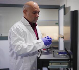 Pathologist preparing a molecular diagnostic sample in a clinical laboratory to support precision oncology decision-making.