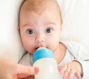 Mother feeding baby with a milk bottle. Image: Oksana Kuzmina/Shutterstock.com.