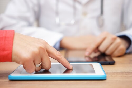 Doctor sharing data on a tablet. Image: Bacho/Shutterstock.com