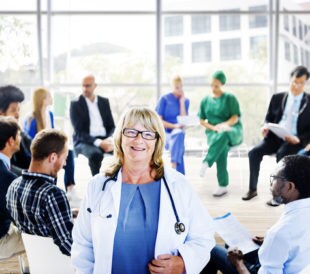 Female doctor standing in front of a support group. Image: awpixel.com/Shutterstock.com.