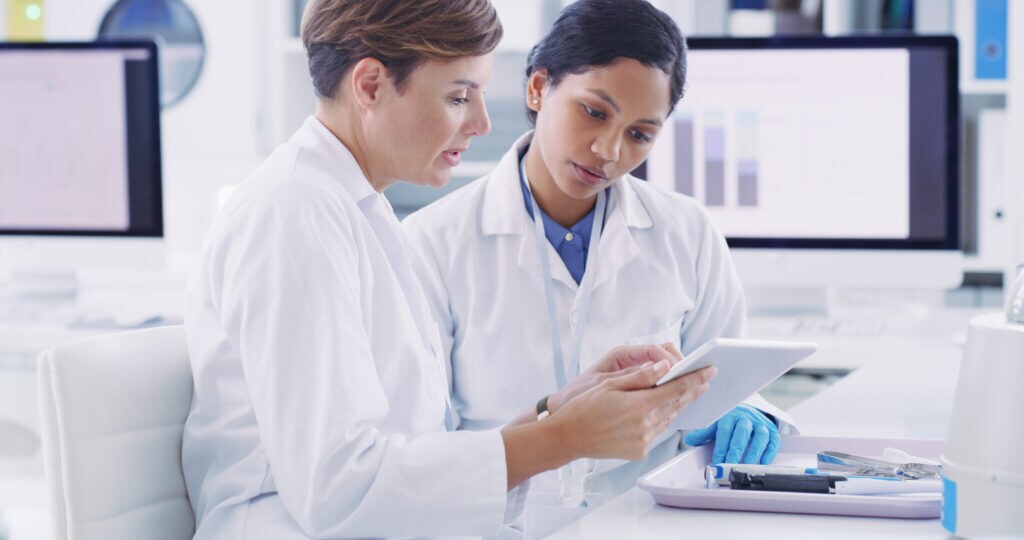Two female scientists working on a tablet in a laboratory 