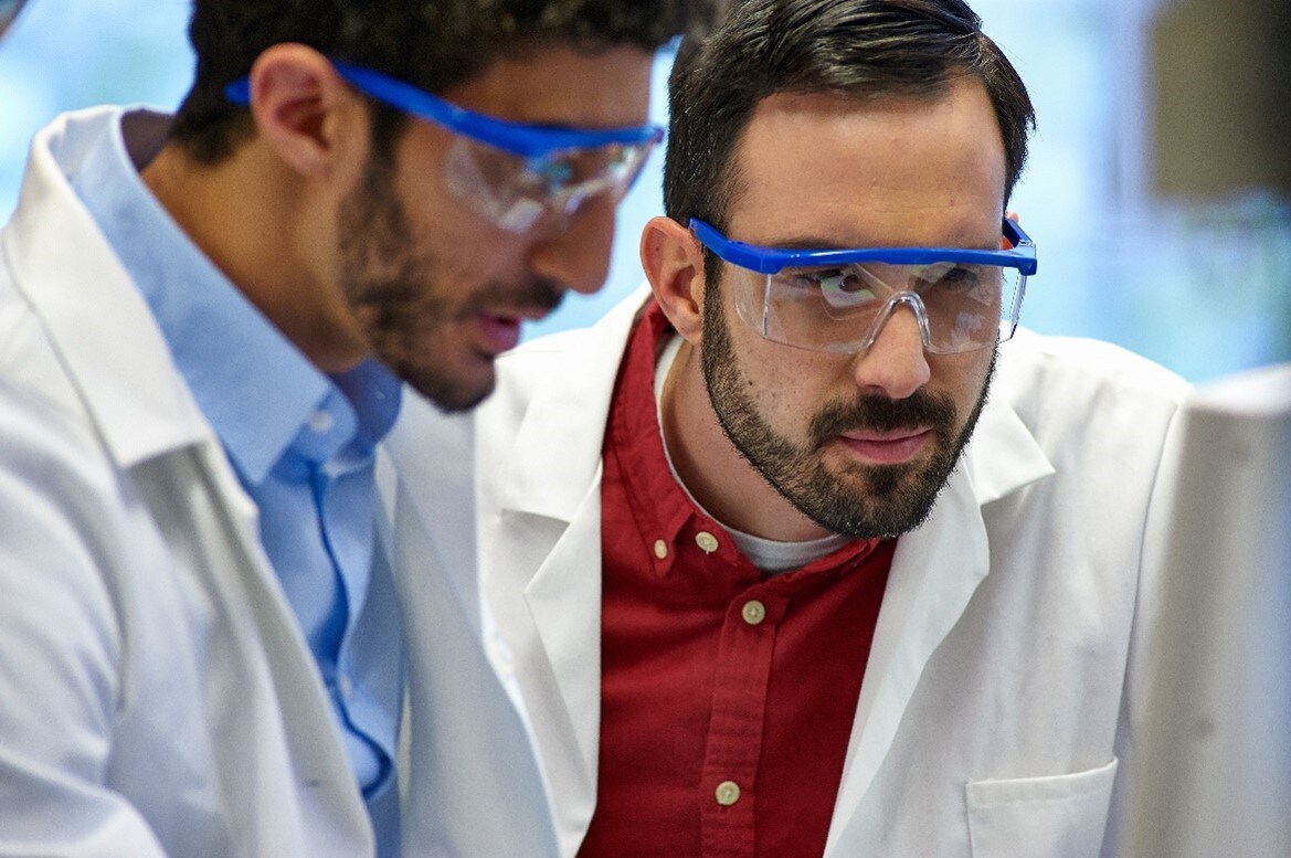 Two lab technicians looking at a monitor