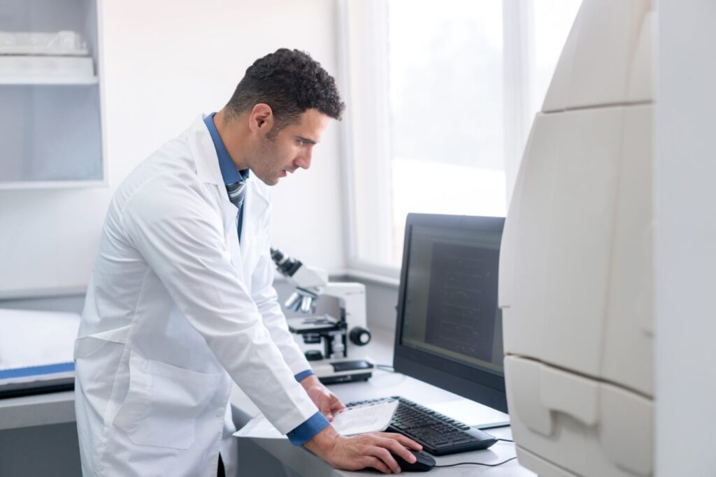 Scientist working at a desktop computer in a lab