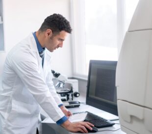Scientist working at a desktop computer in a lab