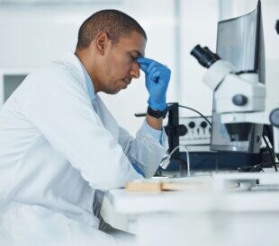 Male scientist looking frustrated at lab bench