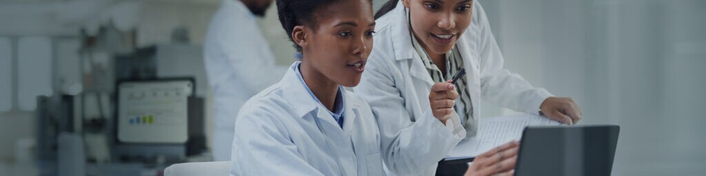 Two female scientists working at a computer in a laboratory