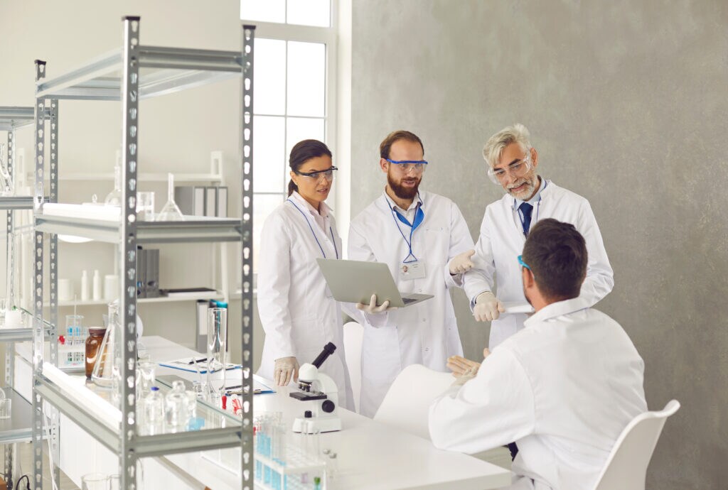 4 scientists discussing results in a laboratory