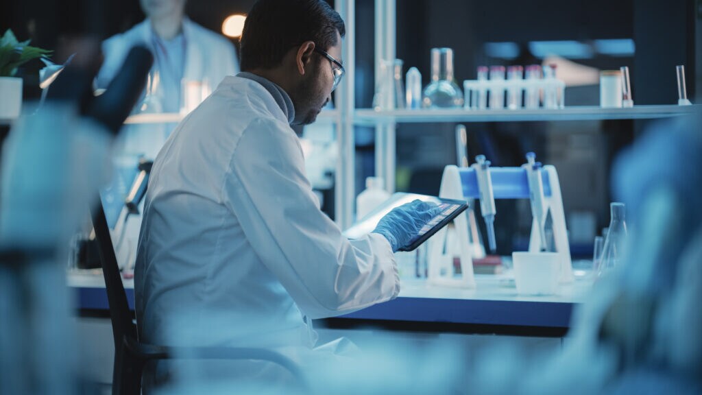Scientist in a laboratory working on a tablet device.