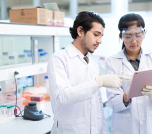 Scientists in lab using a tablet
