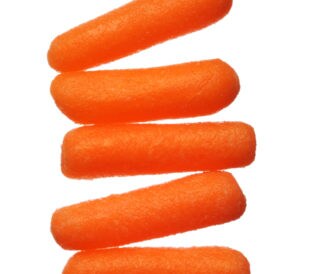 Five baby carrots lined up, isolated on a white background