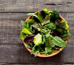 Microgreens in a bowl on a wooden table