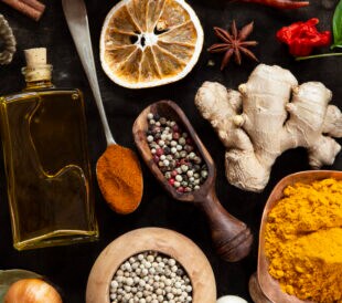 Various herbs and spices on black background - top view