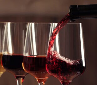 Pouring wine from bottle into glass.