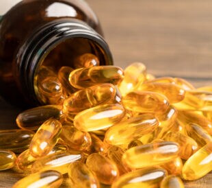 Fish oil Omega 3 capsules vitamin with EPA and DHA isolated on wooden background.