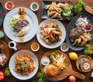 Top looking down at restaurant food spread on table.