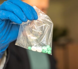 close-up of package in hands with gloves hands blurred out of focus