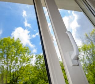 opened plastic vinyl window on green trees background