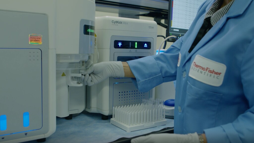 A scientist loads her sample into the Attune CytPix Flow Cytometer