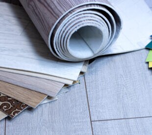 A piece of linoleum for samples. Sliced wood grain linoleum. Multi-colored floor coverings. Measurement and cutting of pvc coating. Roll.