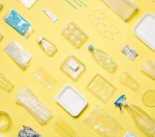 Different types of used plastic packaging arranged on a yellow background