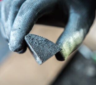 Mechanic holding a pice of broken catalytic converter