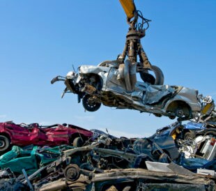 Crane picking up a car in a junkyard
