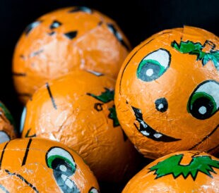 Close up of Halloween Jack-o-lantern foil covered sweets. Ready to hand out to Trick or Treaters.