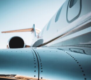 Detail of a corporate jet fuselage, rivets, and engine