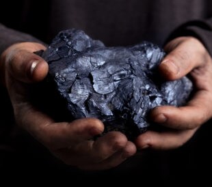 Large-- miner holding a piece of coal