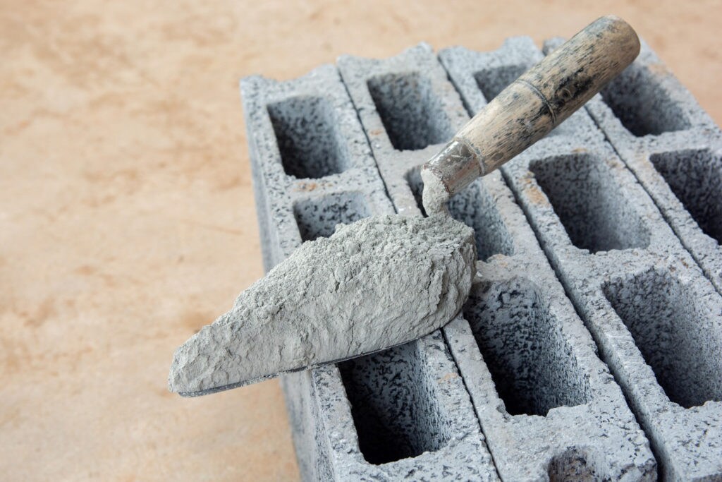 Cement powder or mortar with trowel put on the Concrete brick for construction work.
