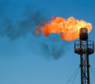 Burning oil flare on a blue skyBurning and smoking oil gas flare