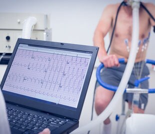 Man doing fitness test on an exercise bike. Image: wavebreakmedia/Shutterstock.com