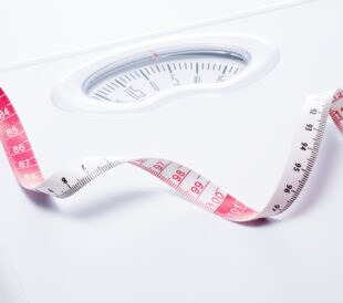 Close-up of a tape measure and bathroom scale. Image: kai keisuke/Shutterstock.com.