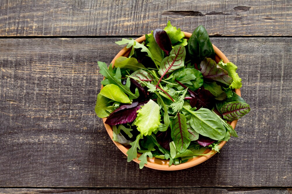 Microgreens in a bowl on a wooden table