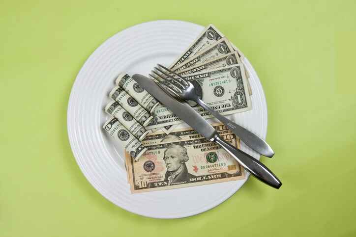 money on plate with fork and knife