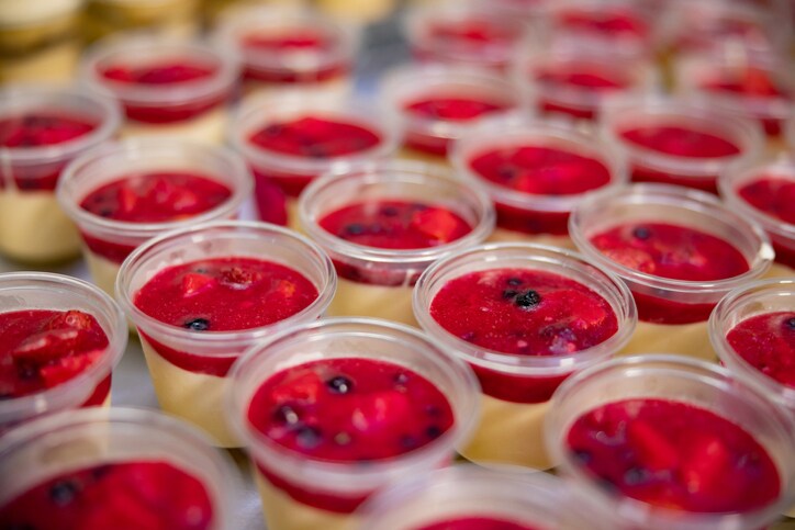 Close-up on a bunch of desserts in portions at an industrial bakery - food processing plant