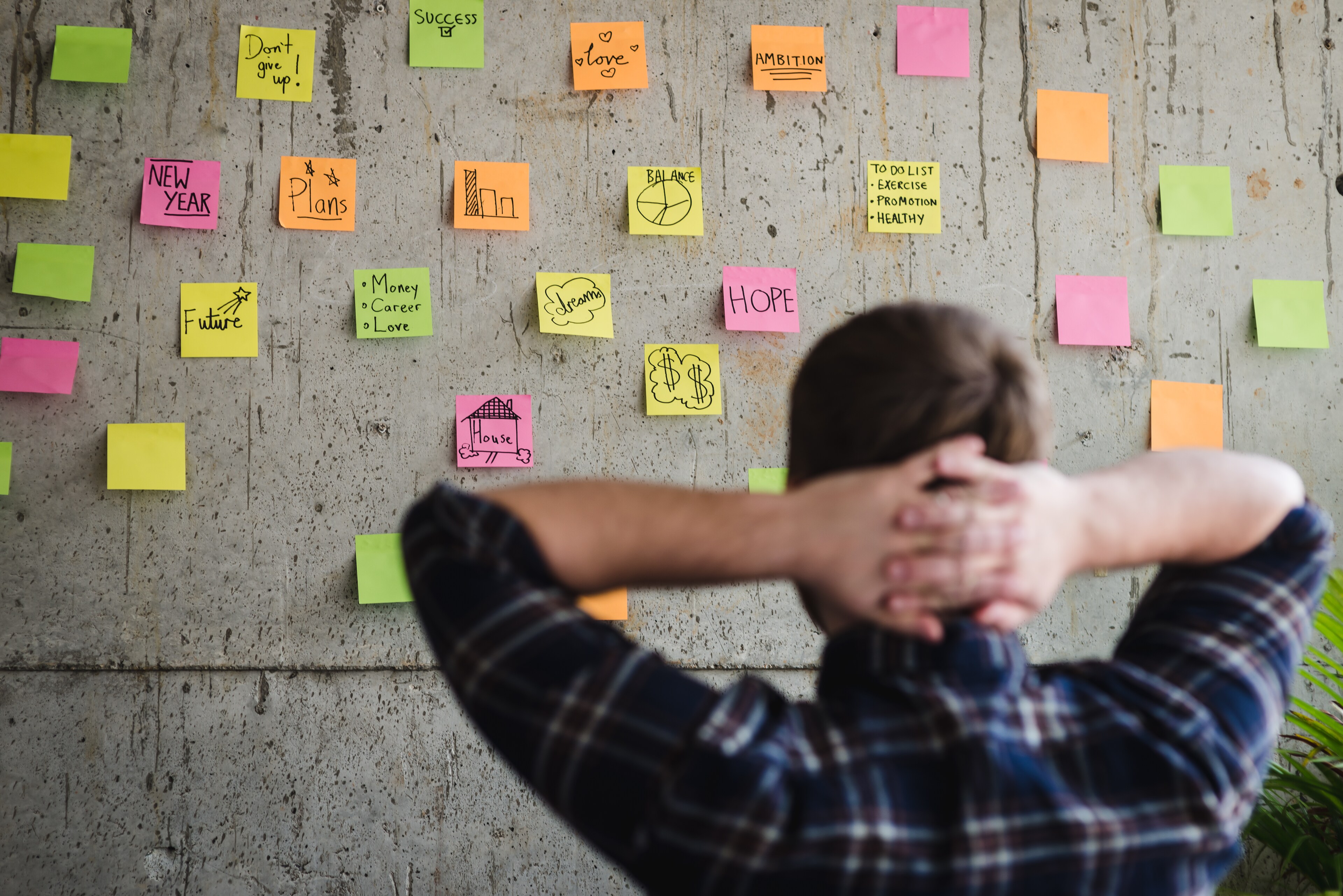 A founder looks at a wall of post-it notes