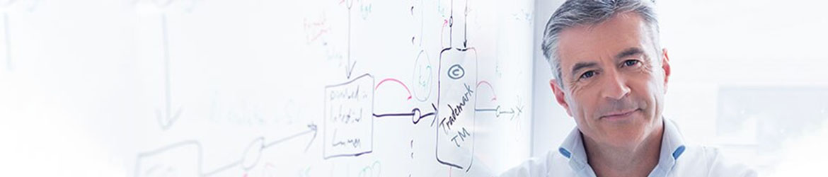 Scientist stands next to whiteboard Hand drawn project plans show the progress that needs to be made