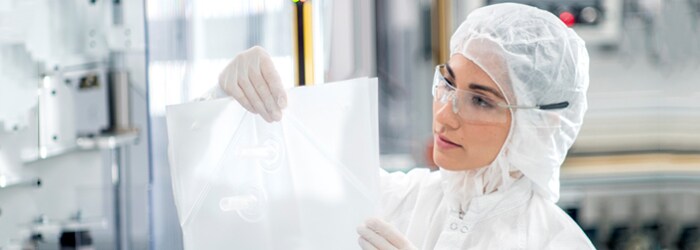 Single-Use Technology Solutions for Cell and Gene Therapy Applications Fully gowned quality professional inspects a BPC chamber in a clean room