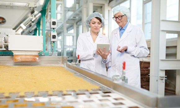 Quality control inspectors looking at LIMS software on tablet in food manufacturing plant Quality control inspectors looking at LIMS software on tablet in food manufacturing plant