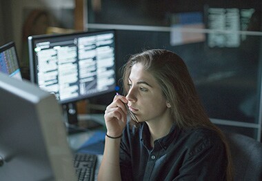 Electron microscopy image of a material surface Woman looking at computer monitor in dark office