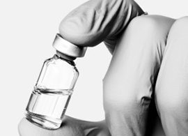 GMP raw material Gloved hand holding a vial