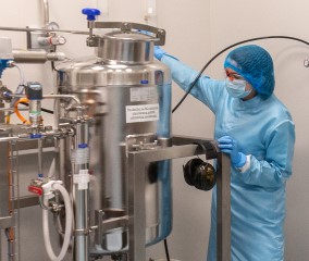 mRNA raw material production Person operating a bioreactor