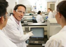 Custom Services three researchers in lab in front of laptop