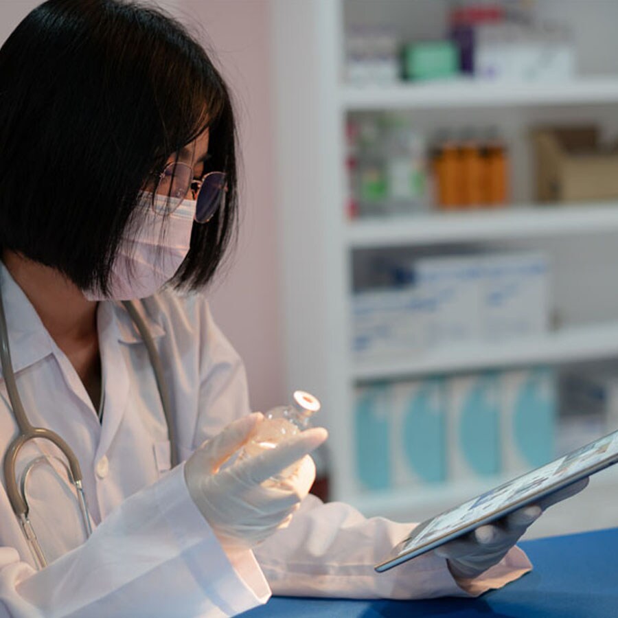scientist looking at tablet while holding a vial Reviewing your data is important to experimental success